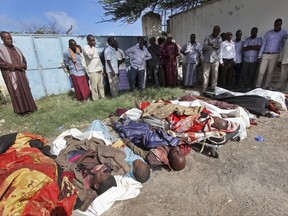 Somalis observe bodies which were brought to and displayed in the capital Mogadishu, Somalia Friday, Aug. 25, 2017. A number of civilians are dead after a raid by foreign and Somali forces on a farm in Barire village in southern Somalia, according to the deputy governor of Lower Shabelle region. (AP Photo/Farah Abdi Warsameh)