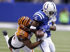 Indianapolis Colts wide receiver JoJo Natson, right, fumbles as he is hit by Cincinnati Bengals cornerback Bene Benwikere (23) during the first half of a preseason NFL football game in Indianapolis, Thursday, Aug. 31, 2017. The Colts maintained possession. (AP Photo/Michael Conroy)