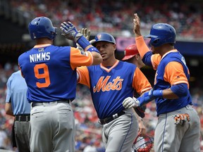 New York Mets' Asdrubal Cabrera, center, celebrates his three-run home run with Brandon Nimmo (9) and Juan Lagares, right, during the first inning of the first baseball game of a split doubleheader against the Washington Nationals, Sunday, Aug. 27, 2017, in Washington. (AP Photo/Nick Wass)