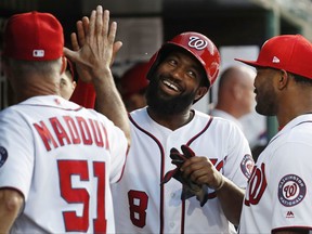 Washington Nationals' Brian Goodwin (8) celebrates in the dugout with pitching coach Mike Maddux (51), and Howie Kendrick (4) after scoring during the third inning of baseball game against the Miami Marlins, Tuesday, Aug. 8, 2017, in Washington. (AP Photo/Carolyn Kaster)