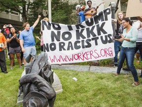 Protesters celebrate after toppling a statue of a Confederate solder in Durham, N.C. Monday, Aug. 14, 2017. Activists on Monday evening used a rope to pull down the monument outside a Durham courthouse. The Durham protest was in response to a white nationalist rally held in Charlottesville, Va., over the weekend. (Casey Toth/The Herald-Sun via AP)
