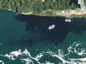 In this July 29, 2017 photo provided by Rainbow Air INC., black-colored wastewater treatment discharge is released into water below Niagara Falls, in Niagara Falls, N.Y.