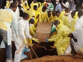 Volunteers handle a coffin during a mass funeral for victims of heavy flooding and mudslides in Regent at a cemetery in Freetown, Sierra Leone, Thursday, Aug. 17, 2017. The government has begun burying the 350 people killed earlier this week in mudslides in Sierra Leone's capital, and it warned Thursday of new danger from a large crack that has opened on a mountainside where residents were told to evacuate.
