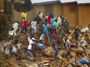 Volunteers search for bodies from the scene of heavy flooding and mudslides in Regent, just outside of Sierra Leone's capital Freetown. Tuesday, Aug. 15 , 2017. Survivors of deadly mudslides in Sierra Leone's capital are vividly describing the disaster as President Ernest Bai Koroma says the nation is in a "state of grief." (AP Photo/ Manika Kamara)