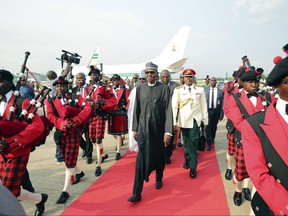 In this photo released by the Nigeria State House, Nigeria President, Muhammadu Buhari, centre, walks upon his arrival at the Nnamdi Azikiwe airport in Abuja, Nigeria, Saturday, Aug. 19, 2017. Buhari has returned to the country after more than three months in London for medical treatment. His office says Buhari will address the nation in a broadcast Monday morning. The government of Africa's most populous nation has never said what exactly has been ailing the 74-year-old leader. (Sunday Aghaeze/Nigeria State House via AP)