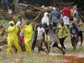 Rescue workers carry the body of a victim from the site of a mudslide in Regent, east of Freetown, Sierra Leone, Monday, Aug. 14, 2017. Mudslides and torrential flooding has killed many people in and around Sierra Leone's capital early Monday following heavy rains, with many victims thought to be trapped in homes buried under tons of mud.