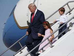 President Donald Trump walks down the steps of Air Force One with his grandchildren, Arabella Kushner, center, and Joseph Kushner, right, after arriving at Morristown Municipal Airport to begin his summer vacation at his Bedminster golf club, Friday, Aug. 4, 2017, in Morristown, N.J. (AP Photo/Evan Vucci)