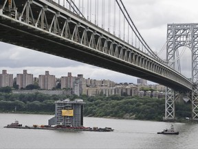 A large generator passes under the George Washington Bridge as seen from Fort Lee, N.J., Tuesday, Aug. 8, 2017.  The 130-foot-(40-meter)-tall steam generator built along the Hudson River outside Albany is on a barge heading south for a New Jersey power plant. (AP Photo/Seth Wenig)