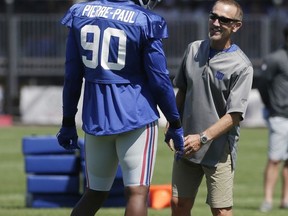 New York Giants' Jason Pierre-Paul, left, talks with defensive coordinator Steve Spagnuolo during NFL football training camp in East Rutherford, N.J., Sunday, July 30, 2017. (AP Photo/Seth Wenig)