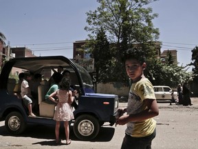 In this Tuesday, Aug. 1, 2017 photo, Egyptian entrepreneur Ahmed Saeed el-Feki, who hopes to reshape the country's automobile industry with his new minicar, takes the vehicle for a test drive in the village of Kerdasa, not far from the Giza Pyramids, greater Cairo, Egypt. El-Feki's golf-cart looking minicar is different in design and mechanical efficiency from the Chinese Tuk Tuk, a three-wheeled motorized vehicle used as a taxi, which is popular in Egypt. (AP Photo/Nariman El-Mofty)