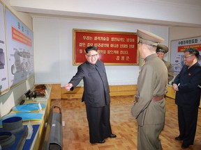 Kim Jong Un, left, visits the Chemical Material Institute of Academy of Defense Science at an undisclosed location in North Korea