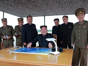 In this Aug. 29, 2017 photo distributed on Wednesday, Aug. 30, 2017, by the North Korean government, leader Kim Jong Un, centre, inspects the test launch of a Hwasong-12 intermediate range missile in Pyongyang, North Korea.