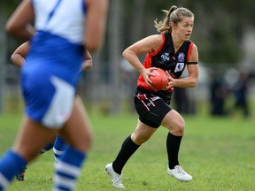 In this Aug. 20, 2014 photo, Canadian national Australian rules football player Aimee Legault carries the ball against Tonga at the International Cup.