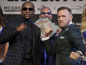 Floyd Mayweather Jr., left, and Conor McGregor pose for photographers during a news conference Wednesday, Aug. 23, 2017, in Las Vegas. The two are scheduled to fight in a boxing match Saturday in Las Vegas. (AP Photo/John Locher)