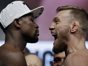 Floyd Mayweather Jr., left, and Conor McGregor face off during weigh-ins Friday, Aug. 25, 2017, in Las Vegas. The two are scheduled to fight in a boxing match Saturday. (AP Photo/John Locher)