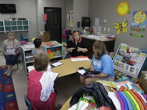 In this photo taken Aug. 8, 2017, Kelsey Nellis, second from right, instructs employees in preparation for the start of the school year at the Mountain View Christian Schools in Las Vegas. More than a third of U.S. states have created school voucher programs that bypass thorny constitutional and political issues by turning them over to non-profits that rely primarily on businesses to fund them. But the programs are raising questions about transparency and accountability at a time when supporters are urging that it be expanded into a federal program. (AP Photo/John Locher)