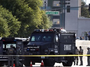 SWAT vehicles and officers stand on scene in Las Vegas after a police officer was shot Tuesday, Aug. 1, 2017. Police in Las Vegas say an officer is in stable condition at a hospital after being shot while responding to a report of a suspicious vehicle. (Steve Marcus/Las Vegas Sun via AP)