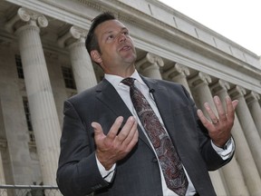 FILE - In this Aug. 23, 2016 file photo, Kansas Secretary of State Kris Kobach responds to questions outside the 10th U.S. Circuit Court of Appeals in Denver.  A lawsuit by a former employee alleging that she was fired from Kobach's office because she didn't attend church enough is going to trial in federal court. While Kobach's top deputy is blamed for the firing in the lawsuit, Kobach is listed as a potential witness and answered questions from attorneys in a videotaped interview. The case also could shine an unwelcome spotlight on Kobach's staff office at the start of his campaign for governor and as he leads a presidential commission on election fraud .(AP Photo/David Zalubowski)