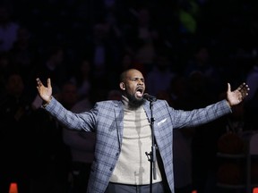 FILE - In this Nov. 17, 2015 file photo. musical artist R. Kelly performs the national anthem before an NBA basketball game between the Brooklyn Nets and the Atlanta Hawks in New York.  Officials in a Georgia county want an upcoming concert by R. Kelly canceled after a media report accusing the singer of mental and physical abuse of women. The Fulton County Board of Commissioners this week sent a letter asking Live Nation, the company contracted to book events at a county-owned venue outside Atlanta, to cancel Kelly's Aug. 25, 2017 concert.(AP Photo/Frank Franklin II)