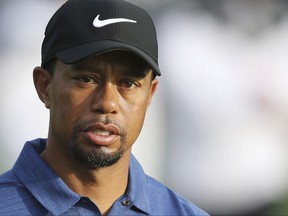 FILE - In this Feb. 2, 2017, file photo, Tiger Woods reacts on the 10th hole during the first round of the Dubai Desert Classic golf tournament in Dubai, United Arab Emirates. The attorney for Woods says the golfer will not attend his arraignment on a driving under the influence charge. Under court rules, Woods' attorney can enter a not guilty plea on his behalf Wednesday, Aug. 9, 2017. Any other plea would require Woods' attendance.(AP Photo/Kamran Jebreili, File)