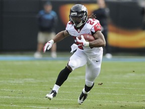 FILE - In this Dec. 24, 2016, file photo, Atlanta Falcons' Devonta Freeman (24) runs against the Carolina Panthers in the first half of an NFL football game in Charlotte, N.C. The Atlanta Falcons have agreed to terms on a five-year contract extension with running back Devonta Freeman, addressing one of the biggest issues for the defending NFC champions. The deal was announced Wednesday, Aug. 9, 2017 on the eve of the team's first preseason game at Miami.  (AP Photo/Mike McCarn, File)