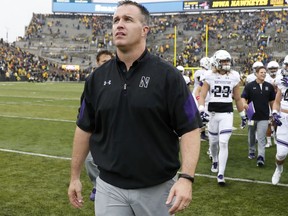 FILE - In this Oct. 1, 2016, file photo, Northwestern head coach Pat Fitzgerald walks off the field after defeating Iowa, 38-31, in an NCAA college football game in Iowa City, Iowa. When it comes to in-game strategy, a six-year-old company named Championship Analytics, Inc., is quickly making a mark. CAI has gone from three schools subscribing to its service in 2014 to 53 this year, including 38 FBS teams. Pat Fitzgerald's Northwestern program is among 22 Power Five conferences schools that have purchased a subscription to CAI's services. (AP Photo/Charlie Neibergall, File)