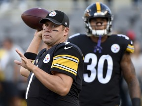FILE - In this Saturday, Aug. 26, 2017 file photo, Pittsburgh Steelers quarterback Ben Roethlisberger (7), left, stands beside running back James Conner (30) as they warm up before an NFL preseason football game against the Indianapolis Colts in Pittsburgh. AFC North revolves around QB longevity, except in Cleveland. With Big Ben's return, the pecking order in the AFC North is set. The Steelers are favored again to win a division that is a model of quarterback continuity, except in Cleveland.  (AP Photo/Fred Vuich, File)