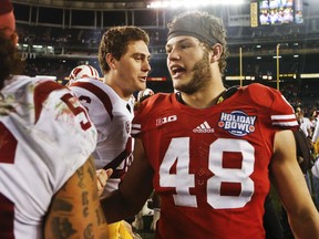 FILE - This Dec. 30, 2015, file photo shows Wisconsin linebacker Jack Cichy being congratulated by Southern California players after Wisconsin's 23-21 victory at the Holiday Bowl NCAA college football game in San Diego. Over his career at Wisconsin, fifth-year senior Jack Cichy has had two head coaches and three defensive coordinators while also playing multiple positions. So many different voices have offered direction to Cichy, and yet Bob Bostad may be his most unique position coach yet. (AP Photo/Lenny Ignelzi, File)