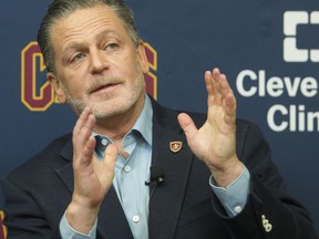 FILE - In this July 26, 2017, file photo, Cleveland Cavaliers chairman gestures during a press conference at he Cavaliers training facility in Independence, Ohio. Gilbert vowed Thursday, Aug. 31, 2017, to "never" move his NBA franchise from Cleveland. Earlier this week, Gilbert scrapped plans for a $140 million renovation for Quicken Loans Arena and that decision spawned speculation he might leave the city when his lease expires in 2027. (AP Photo/Phil Long, File)