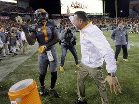 FILE - In this Dec. 30, 2016, file photo, Tennessee head coach Butch Jones slaps hands with defensive lineman Jonathan Kongbo (1) after Kongbo poured Gatorade on Jones after Tennessee defeated Nebraska, 38-24, in the Music City Bowl NCAA college football game, in Nashville, Tenn. Touted as one of the nation's top junior-college prospects when he signed with Tennessee last year, Kongbo recorded just one sack last season and struggled to adapt to a different role as this natural defensive end saw occasional playing time at tackle. Kongbo says he's learned from the experience. .(AP Photo/Mark Humphrey, File)