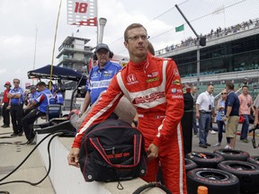 FILE - In this May 19, 2017, file photo, Sebastien Bourdais, of France, unpacks his helmet as he prepares to drive during a practice session for the Indianapolis 500 IndyCar auto race at Indianapolis Motor Speedway in Indianapolis. Bourdais has been cleared to resume racing, nearly three months after crashing during Indianapolis 500 qualifying. IndyCar medical director Dr. Geoffrey Billows said Wednesday, Aug. 16, that the 38-year-old Frenchman was evaluated by IndyCar orthopedic consultant Dr. Kevin Scheid on Tuesday and given clearance to fully return to racing activities. (AP Photo/Michael Conroy, File)