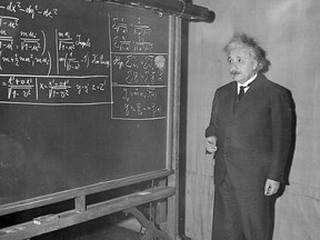 FILE - In this Dec. 28, 1934 file photo, Albert Einstein uses a blackboard as he speaks at a meeting of the American Association for the Advancement of Science in Pittsburgh, Pa. In 1915, then a little known scientist, Einstein proposed his general theory of relativity, a milestone in physics that says what we perceive as the force of gravity is actually from the curvature of space and time. He couldn't prove it, but did say there were three ways to prove it and one was to show how distant star light bends during an eclipse. In 1919, Arthur Eddington observed the right amount of bending, something they couldn't do without the moon's shadow eclipsing the sun. (AP Photo)