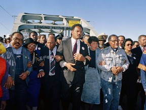 FILE - In this March 4, 1990 file photo, civil rights figures lead marchers across the Edmund Pettus Bridge during the recreation of the 1965 Selma to Montgomery march in Selma, Ala. From left are Hosea Williams of Atlanta, Georgia Congressman John Lewis, Rev. Jesse Jackson, Evelyn Lowery, SCLC President Joseph Lowery and Coretta Scott King. In August 2017, Jackson used a Chicago Sun-Times opinion to praise Heather Heyer, the 32-year-old woman who died in the vehicular attack in Charlottesville, Va. Jackson wrote that she "joins the martyrs of America's long struggle for equal rights." (AP Photo/Jamie Sturtevant)