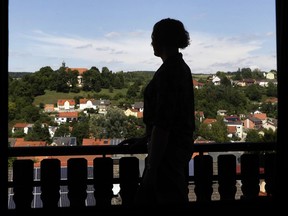 In this July 29, 2017 photo transgender U.S. army captain Jennifer Sims is silhouetted on a balcony after an interview with The Associated Press in Beratzhausen near Regensburg, Germany. (AP Photo/Matthias Schrader)