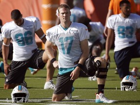 FILE - In this July 27, 2017, file photo, Miami Dolphins quarterback Ryan Tannehill (17) stretches with teammates during NFL football training camp in Davie, Fla. A person familiar with the decision says Tannehill will have surgery to repair the torn ACL in his left knee and will miss the entire season. The person confirmed the decision to The Associated Press on condition of anonymity Friday, Aug. 11, 2017, because the Dolphins had not disclosed it publicly. (AP Photo/Wilfredo Lee, File)