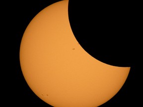 The moon is seen as it starts passing in front of the sun during a solar eclipse from Ross Lake, Northern Cascades National Park, in Washington on Monday, Aug. 21, 2017.