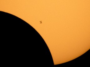 The International Space Station is silhouetted against the sun during a partial solar eclipse Monday, Aug. 21, 2017, as seen from Ross Lake, Northern Cascades National Park, in Washington. (Bill Ingalls/NASA via AP)