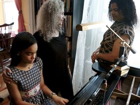 In this Thursday, Aug. 17, 2017, photo, Julie Wegener, center, a music teacher with the MusicLink Foundation, her student Anmy Paulino Collado, left, and Anmy's mom, Andolina Collado, as they finish a music session, in New York. Private music lessons are beyond the reach of many families and even music programs at public schools can come at a price. Even for families with means, there are tricky questions. Who wants to invest several hundred dollars in a guitar that might end up in the closet? Before plunging into music lessons, it helps to explore the landscape. (AP Photo/Bebeto Matthews)