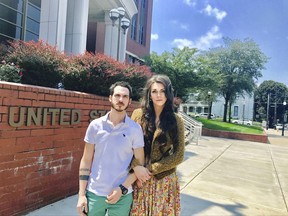 This Aug. 4, 2017, photo provided by Jillian Weiss shows Dane Lane, left, and his transgender wife, Allegra Schawe-Lane, outside the federal courthouse in Covington, Ky. The couple is filing a lawsuit against Amazon, alleging that they endured sustained discrimination and harassment during a year as co-workers at an Amazon warehouse in Kentucky. (Jillian Weiss via AP)