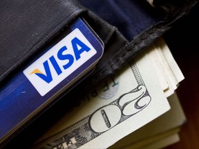 FILE - In this Feb. 2, 2011, file photo, a wallet containing cash and a Visa card is displayed in Surfside, Fla. Peers can hold you accountable and keep you motivated with financial goals. (AP Photo/Wilfredo Lee, File)