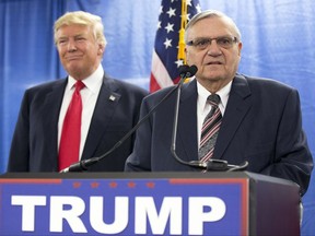 FILE - In this Jan. 26, 2016, file photo, then-Republican presidential candidate Donald Trump is joined by Joe Arpaio, the then sheriff of metro Phoenix, during a news conference in Marshalltown, Iowa. Trump isn't expected to take action Tuesday, Aug. 22, 2017, on a possible pardon of Arpaio's conviction for intentionally disobeying a judge's order in an immigration case. White House press secretary Sarah Huckabee Sanders told reporters that the president would take no action Tuesday on Arpaio as Trump plans to appear in the evening at a rally in downtown Phoenix. (AP Photo/Mary Altaffer, File)