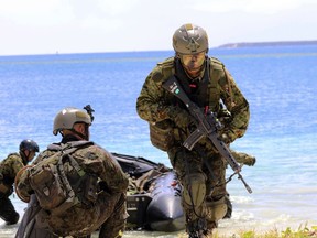 FILE - In this May 13, 2017 file photo, Japanese soldiers use rubber rafts as part of an amphibious drill during joint military exercises between the U.S., Japan, France and the United Kingdom, on Naval Base Guam. North Korea says it is examining its operational plans for attacking Guam to contain U.S. bases there. The army said in a statement distributed Wednesday, Aug. 9 by the state-run news agency that it is studying a plan to create an "enveloping fire" in areas around Guam with medium- to long-range ballistic missiles. The U.S. territory is home to Andersen Air Force Base.  The statement says the move is in response to a recent U.S. ICBM test. (AP Photo/Haven Daley, File)