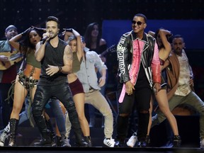 FILE - In this April 27, 2017 file photo, singers Luis Fonsi, left and Daddy Yankee perform during the Latin Billboard Awards in Coral Gables, Fla. The ubiquitous hit song "Despacito" has tied Mariah Carey's 16-week record at No. 1 on the Billboard Hot 100 chart. Billboard announced Monday, Aug. 28, that Luis Fonsi's song and Carey's duet with Boyz II Men, "One Sweet Day," are the longest-running No. 1 songs in the 59-year history of the charts. (AP Photo/Lynne Sladky, File)