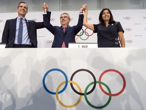 FILE - Int his July 11, 2017, file photo, from left, Mayor of Los Angeles Eric Garcetti, International Olympic Committee (IOC) President Thomas Bach, and Mayor of Paris Anne Hidalgo gesture during a press conference after the IOC Extraordinary Session at the SwissTech Convention Centre in Lausanne, Switzerland. One of the beautiful things about the Olympics is that some of the runners-up get prizes, too. Which brings us to Los Angeles. (Jean-Christophe Bott/Keystone via AP, File)
