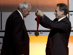 FILE - In this Nov. 22, 2009, file photo, former Michigan State basketball coach Jud Heathcote, left, is presented with a medal by current Michigan State coach Tom Izzo as Heathcote is inducted into the National Collegiate Basketball Hall of Fame in Kansas City, Mo. Heathcote, who led Michigan State and Magic Johnson to the 1979 NCAA championship, has died. He was 90. The school says Heathcote died Monday, Aug. 28, 2017, in Spokane, Washington. (AP Photo/Ed Zurga, File)