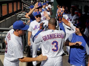 New York Mets' Curtis Granderson (3) is congratulated by teammates after hitting a solo home run against the Los Angeles Dodgers during the first inning of a baseball game, Saturday, Aug. 5, 2017, in New York. (AP Photo/Julie Jacobson)