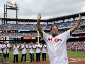 FILE- In this Aug 3, 2013, file photo, former Philadelphia Phillies catcher Darren Daulton waves to the crowd as he takes the field during the Philadelphia Phillies Alumni ceremonies before a baseball game against the Atlanta Braves in Philadelphia. Daulton, the All-Star catcher who was the leader of the Phillies' NL championship team in 1993, has died. He was 55. (AP Photo/Michael Perez, File)