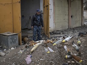 FILE- In this March 22, 2017, file photo, a Federal Police stands next to unexploded bombs left by Islamic State group militants on the western side of Mosul, Iraq. On Thursday, Aug. 17, the top U.S. commander in Iraq said for the first time that the American military will help contractors and other officials locate unexploded bombs dropped by the coalition. U.S. Embassy officials have asked the coalition to declassify grid coordinates for bombs dropped in Iraq to help clear the explosives. The coalition's unexploded bombs are only a small part of Mosul's problems. The bulk of the explosives have been hidden by IS fighters to be triggered by the slightest movement, even picking up a seemingly innocent children's toy, lifting a vacuum cleaner, or opening an oven door. (AP Photo/Felipe Dana, File)