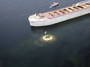 In this photo provided by the U.S. Coast Guard, the merchant vessel Calumet sits aground in shallow water outside of the channel on St. Marys River, which runs between the U.S. and Canada along Michigan's eastern Upper Peninsula, southeast of Sault Ste. Marie, Mich., Thursday, Aug 10, 2017. The Coast Guard says the Calumet left a steel facility in Sault Ste. Marie, Ontario, and was heading to its next port when it ran aground late Wednesday near Sugar Island. No injuries were reported. (U.S. Coast Guard via AP)