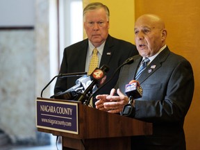 Niagara County Legislator David E. Godfrey, left, looks on as state Assemblyman Angelo J. Morinello calls for the resignation of members of the Niagara Falls water board during a news conference at the Niagara County Courthouse, Thursday, Aug. 3, 2017, in Lockport, N.Y. The call for resignations comes after a discharged of a plume of stinky, black water into the Niagara River near the base of Niagara Falls from the wastewater treatment plant on Saturday, July. 29. (Joed Viera/The Union-Sun & Journal via AP)